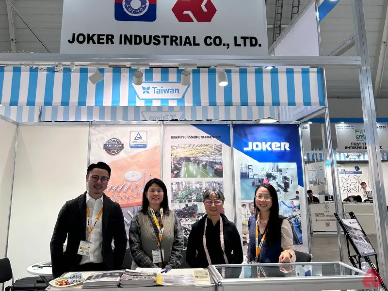 JOKER INDUSTRIAL CO., LTD. 在展覽會上的攤位，四位工作人員在攤位前合影。背景展示了台灣精密製造的相關資訊與公司標誌，強調其專業性與高品質。