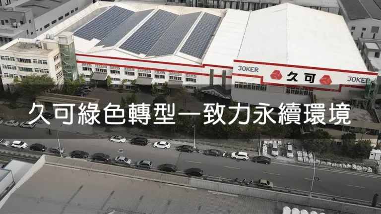 從高處拍攝的久可公司廠房外觀，屋頂裝設大量太陽能板，顯示公司致力於綠色能源發展與永續經營。廠房前停放多輛汽車，展示公司規模。標語「久可綠色轉型 一致力永續環境」