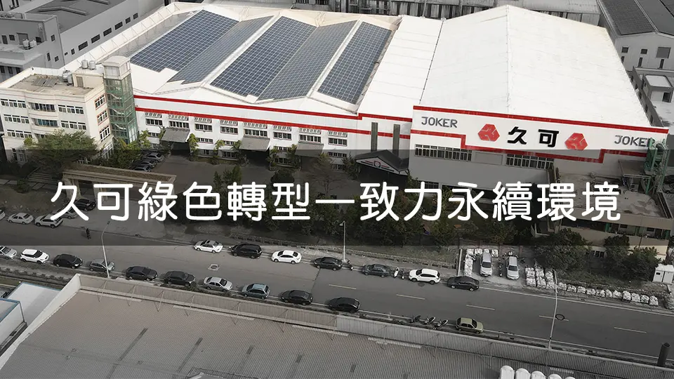 從高處拍攝的久可公司廠房外觀,屋頂裝設大量太陽能板,顯示公司致力於綠色能源發展與永續經營。廠房前停放多輛汽車,展示公司規模。標語「久可綠色轉型 一致力永續環境」